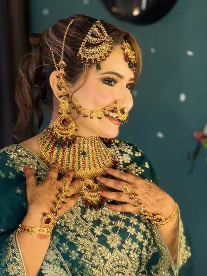 This is one of my signature bride looks, perfect for a Walima or reception. The makeup is glamorous yet sophisticated, with defined eyes, glowing skin, and a lip color that complements her green and gold attire.