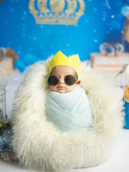 Here comes the little prince, looking cool and confident in his shades. Themed shoots like this 'Royal Prince' setup are a fun way to play with costumes and props.