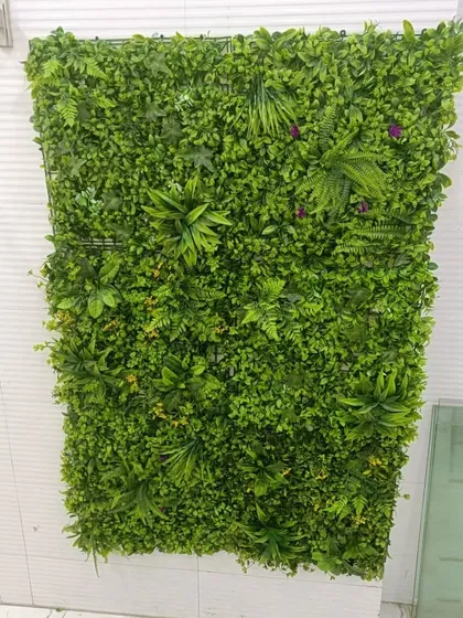 A straight-on view of the artificial green panel used for the under-staircase area. The mix of ferns and purple flowers adds texture and a pop of color.
