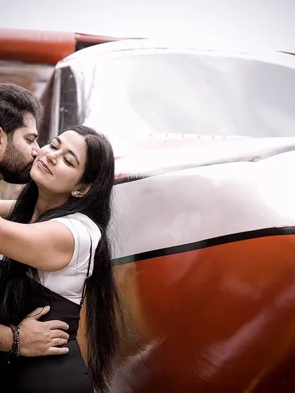 An intimate kiss by the airplane, combining romance with a sense of adventure.