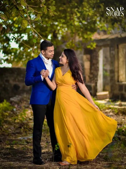 A simple walk in a rustic, natural setting can result in beautiful, heartfelt images. The vibrant colors of the couple's outfits pop against the greenery, creating a warm and romantic pre-wedding photograph.