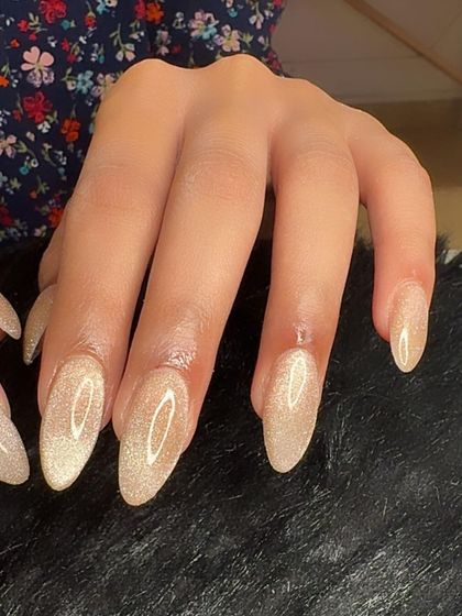 A side view of the champagne cat eye nails, highlighting their almond shape.