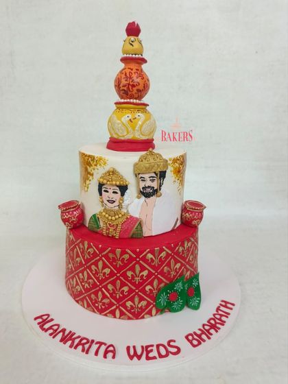This intricate two-tier wedding reception cake was a special one, blending the cultures of Alankrita from West Bengal and Bharath from Kerala. It features a hand-painted caricature, a traditional Bengali mukut, and kalash details, telling their unique story.