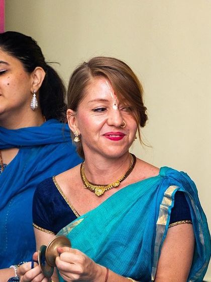 Musicians playing traditional instruments like the kartal (hand cymbals) during a live kirtan, adding to the authentic sound of the chant.