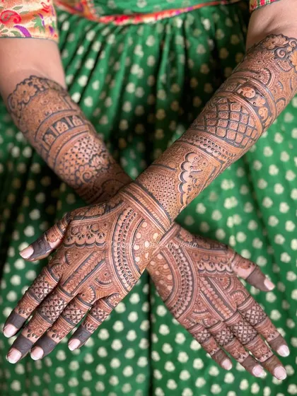 This bridal back-of-hand design is full of intricate details. The patterns are dense and symmetrical, creating a stunning look that complements the front-of-hand design perfectly.