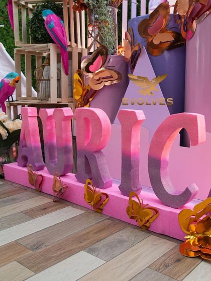 Another angle of the custom "AURICA" name prop, showing how we use details like ombre painting and small butterfly cutouts to enhance the theme.