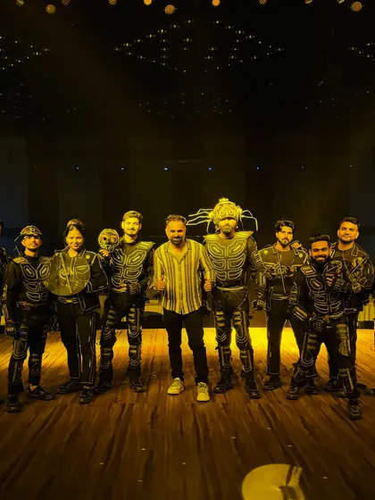 A proud moment for the team, posing on stage after a successful show. You can see the scale of our production and the full lineup of our performers.