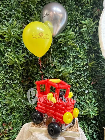 A Rakhi gift for the little one who loves cars. This hamper features a fun tractor sculpture made from red balloons, showing how we can customize gifts for any interest.