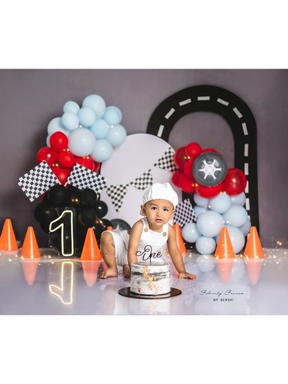 Ready to smash the cake! This little racer is all set for the main event of his first birthday photoshoot.