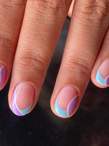 A close-up of the pastel swirl nail art on short, natural nails.