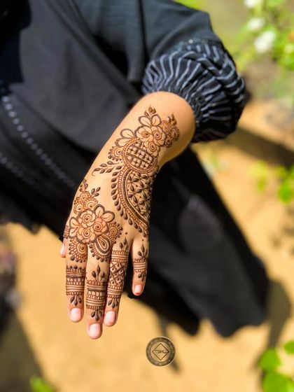 A simple and pretty henna design for Eid, featuring floral and paisley motifs.