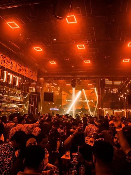 The view of a packed house at Club LITT in Kolkata, with the whole room glowing orange.