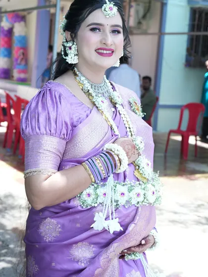 A beautiful portrait of the mom-to-be, showcasing her complete floral look, from the maang tikka and earrings to the layered necklaces and kamarband.
