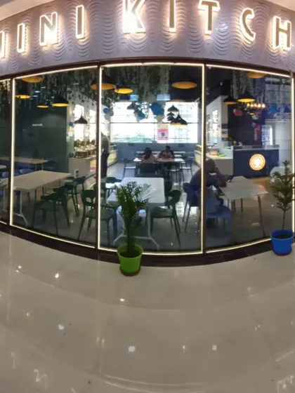 The view of my restaurant from the outside. The large glass windows and bright "Grihini Kitchen" sign make it easy to find and inviting to enter.