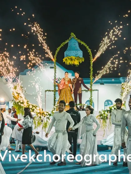 A dreamy varmala theme with a beautiful bell prop. The couple is elevated on a moving stage, surrounded by dancers in white and sparkling cold pyros.