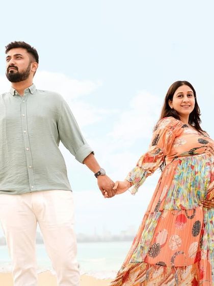 A stunning wide shot of a couple holding hands on the beach, with birds flying overhead for a touch of magic.