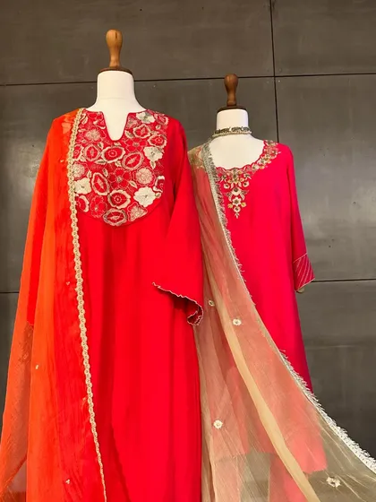 I believe in the power of color. This display showcases radiant red and pink kurtas with contrasting dupattas, featuring beautiful floral embroidery around the neckline.