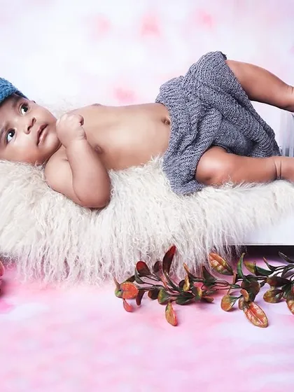 Even when they are wide awake, we can capture beautiful moments. This alert newborn is pictured relaxing in a miniature bed, showing off their curious eyes.