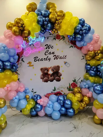 A colorful "We Can Bearly Wait" baby shower theme with a custom backdrop and a vibrant balloon arch.