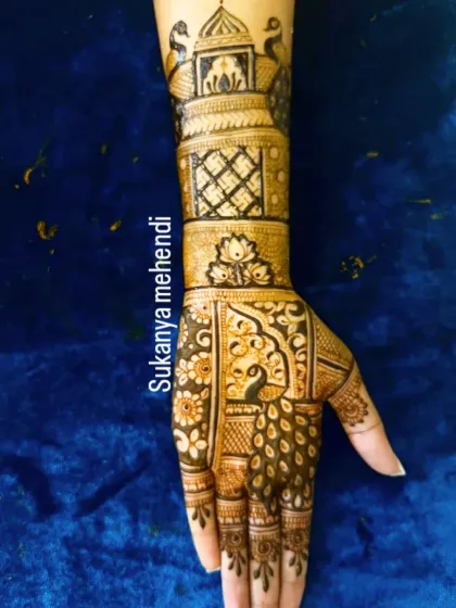 A single-hand view of a bridal design, showcasing a beautiful peacock motif within a jharokha, complemented by lattice work and a palace design on the cuff.