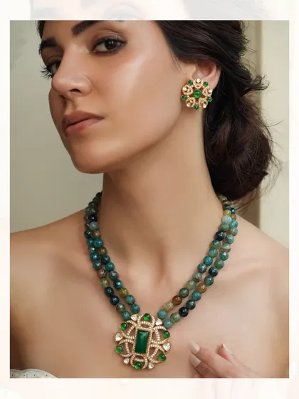 A modern beaded necklace with a large emerald and polki pendant, perfect for destination weddings.