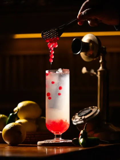 Adding flavor pearls to a sparkling beverage. This macro action shot is visually satisfying and highlights a unique ingredient.