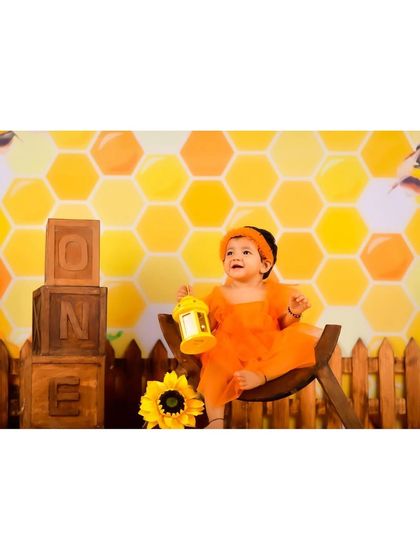 A sweet honeybee-themed shoot for a first birthday, with a honeycomb background and "ONE" blocks.
