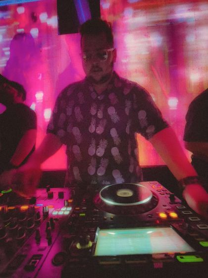 A blurry, artistic shot of me at the console, capturing the vibrant and sometimes chaotic energy of a great party.
