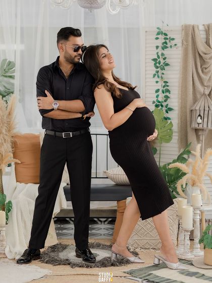 A modern and stylish pose, with the couple leaning back-to-back, exuding confidence and love.