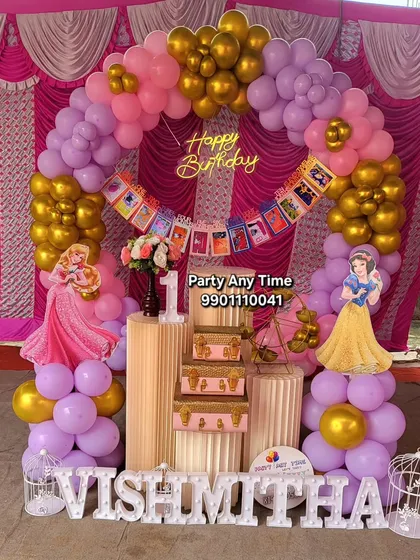 A complete view of the princess theme decoration for Vishmitha's birthday. It features a large balloon arch, princess cutouts, and elegant pedestals, perfect for a royal celebration.