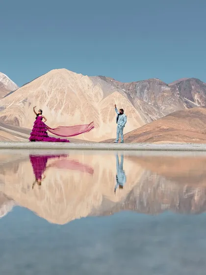 The serene beauty of Leh, where the mountains meet their perfect reflection. This shot captures a quiet, epic moment, with the vibrant purple gown creating a stunning contrast against the tranquil blues and earthy tones of Pangong Lake.