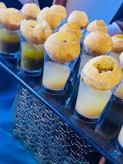 A stylish tray of our flavored Pani Puri Shots ready to be served at a corporate meet. We offer a variety of waters, including classic mint, tangy orange, and sweet and sour tamarind.