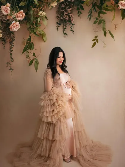 This layered tulle gown is pure fairytale magic. The soft beige and pink tones, combined with the hanging floral arrangement, create an incredibly romantic and dreamy portrait.