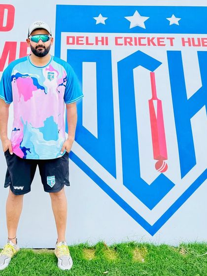 Standing in front of the Delhi Cricket Hub camp banner. To grow, you must step out of your comfort zone, and that's what our camps are all about.