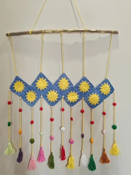 Another view of the vibrant blue and yellow crochet wall hanging. I love how the tassels add movement and a playful touch to the design.