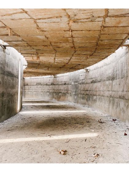 The raw concrete interior of the curved memorabilia gallery, with natural light filtering in from above.