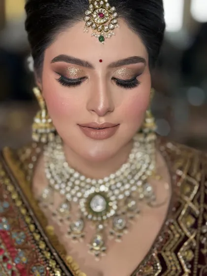 A detailed close-up of the eye makeup. The gold glitter on the lids catches the light beautifully, and the nude matte lip keeps the look balanced and sophisticated.