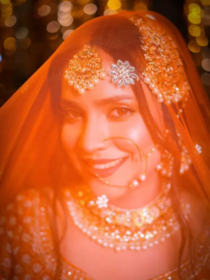 A direct look at the camera through the veil, creating an intimate and engaging bridal shot.