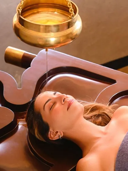 Experience the profound calm of Shirodhara, a timeless Ayurvedic therapy. A gentle, continuous stream of warm, herb-infused oil flows over your forehead, quieting the mind, soothing the nervous system, and restoring a sense of deep inner balance.