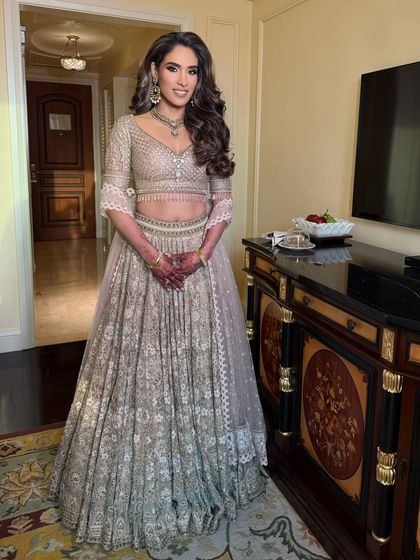 The full look, showcasing a beautiful Tarun Tahiliani lehenga. The hair and makeup are designed to complement the intricate outfit perfectly.