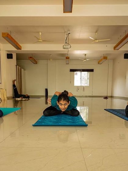 Three young girls practicing a pose together in our spacious shala. When parents practice, their children are often inspired to join, creating a beautiful family habit of wellness.