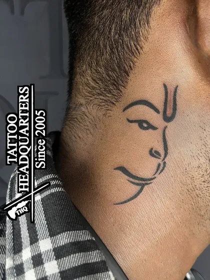 A minimalist outline of Lord Hanuman's face tattooed on the side of the neck, a subtle yet powerful symbol of devotion.