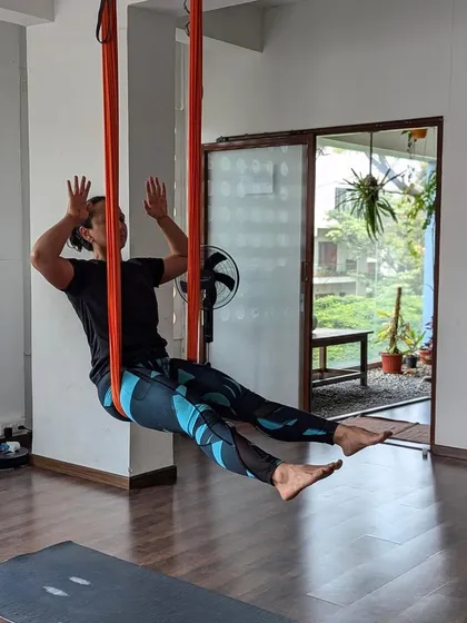 The playful side of practice. A moment of laughter and lightness while exploring movement in the aerial hammock. It's not just a workout; it's a joyful experience.