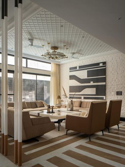 The formal living area showcases a fusion of Indian marble and brick flooring, unified by a monochromatic palette. The design creates a comfortable sanctuary suited for the extreme North Indian climate.