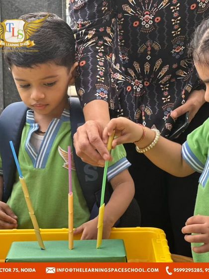 A teacher assists two children with their fine motor task. This shows our collaborative approach, where teachers and students learn and discover together.
