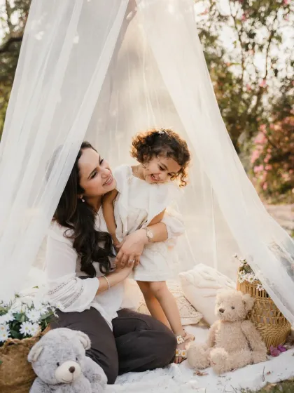 A mother and daughter share a playful moment in their outdoor tent. These candid interactions create the most authentic portraits.