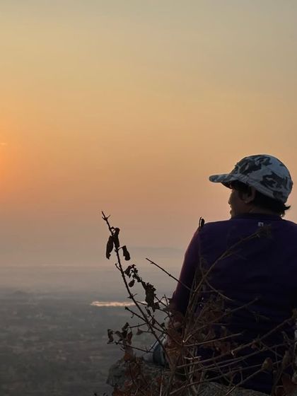 A trekker watching the sunrise, a perfect moment of solitude and connection with nature.