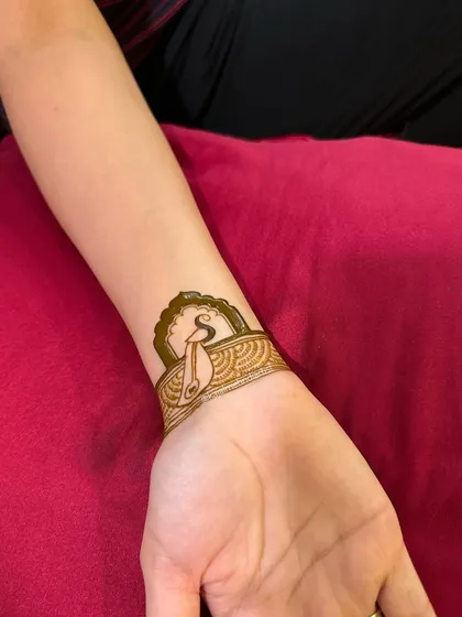 The wristband design taking shape. A patterned cuff is added below the initial, creating a chic and personalized henna bracelet.