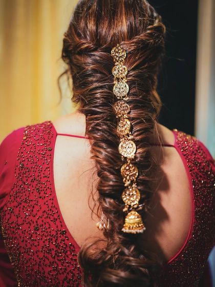 A detailed shot of the beautiful fishtail braid with gold coin accessories, created for Ishita's engagement.