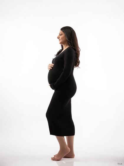 A full-body profile shot in a simple, long-sleeved black dress. This minimalist approach creates a timeless and powerful silhouette.